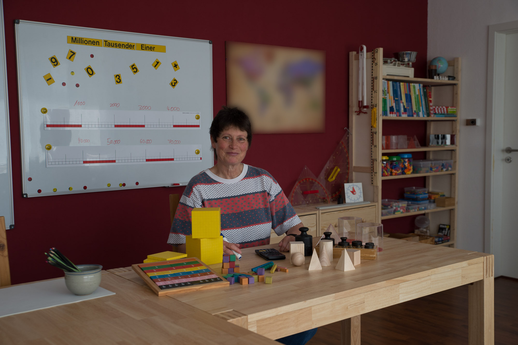 Frau Falkenhain mit Arbeitsmitteln im Therapiezimmer.